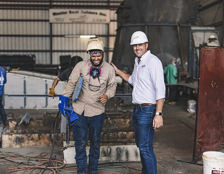 two men working and smiling